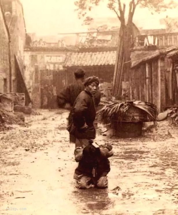 1900年,跪在雨中的犯人,站着的是押送他的官差.